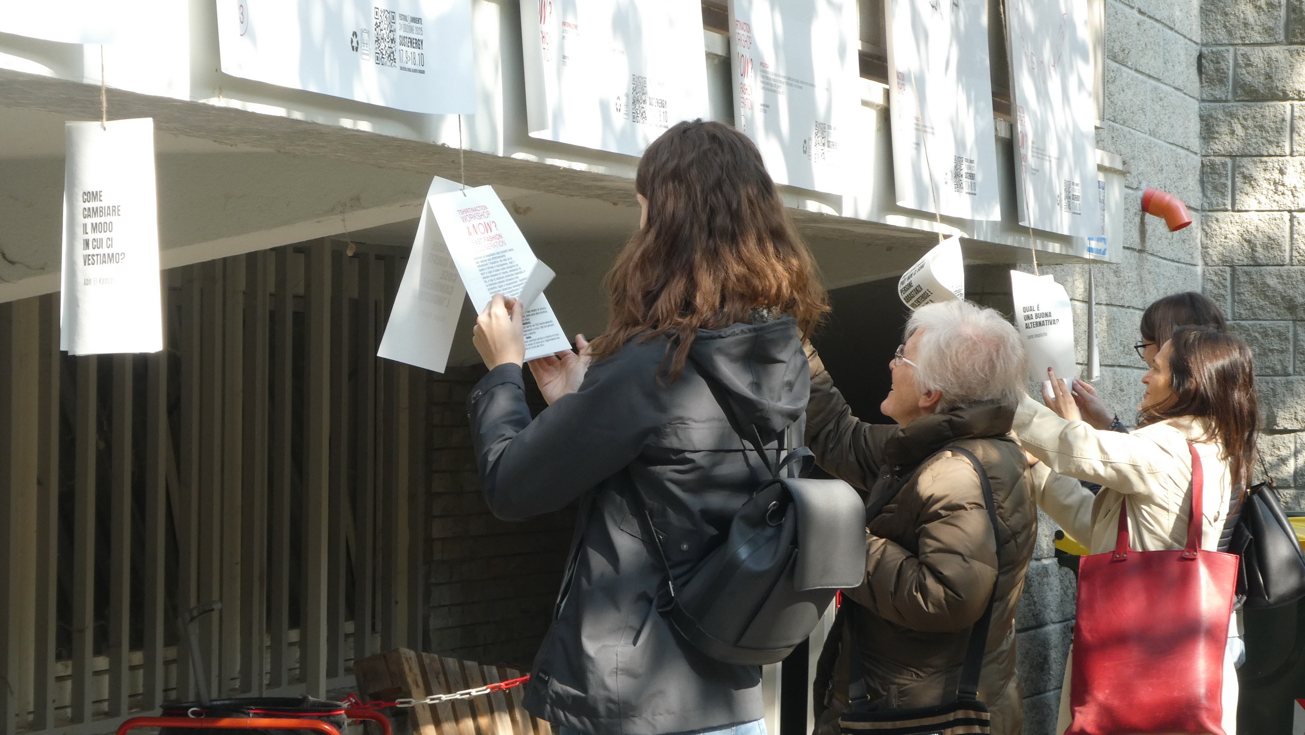 I partecipanti esaminano i cartelli dei manifesti esposti